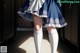 A woman in a blue and white dress and white socks.