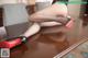 A woman in black stockings and red high heels sitting on a table.