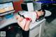 A woman in a red lingerie is laying on a desk.