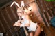 A woman in a bunny costume sitting on a railing.