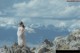 A woman standing on top of a rocky mountain.