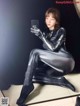 A woman in a black and silver spider suit taking a selfie.