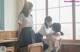 A group of young women sitting at desks in a classroom.